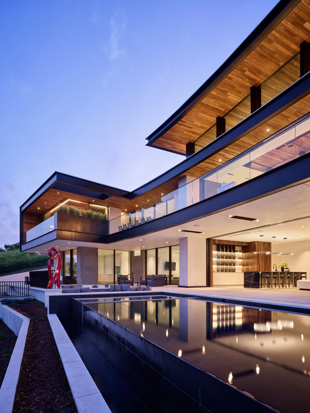 Residencia contemporánea al anochecer con estanque reflectante